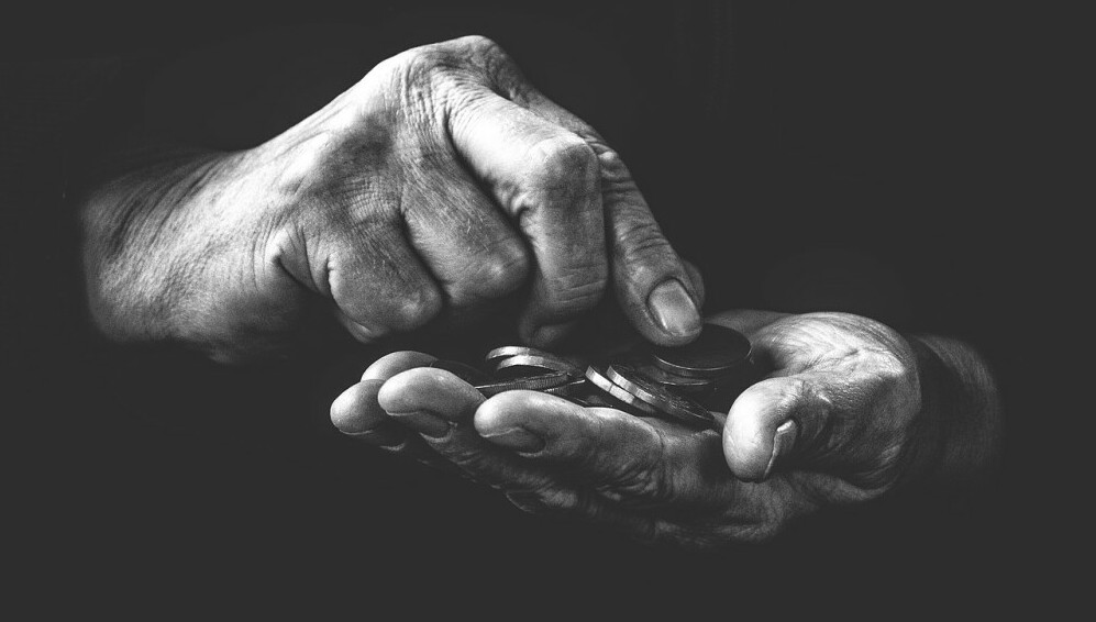 older hands counting coins in their hands