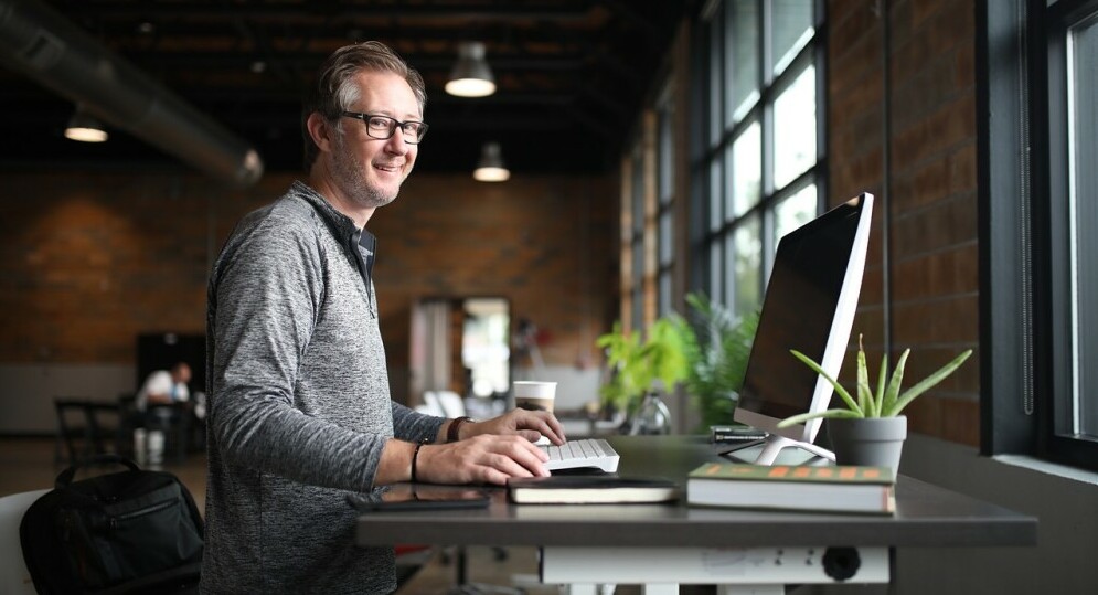 man working standing at a computer